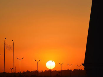 Silhouette street against sky during sunset
