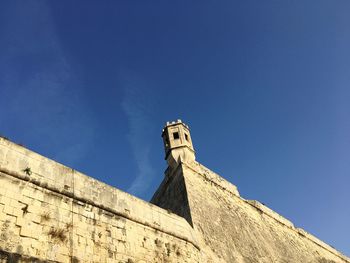 Low angle view of lookout tower on fort at floriana against blue sky