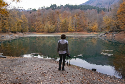 Rear view of girl standing by lake