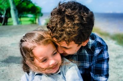 Close-up of brother and sister embracing outdoors