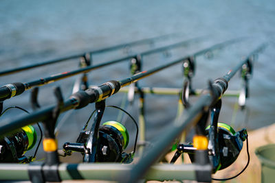 Close-up of fishing reels by the lake