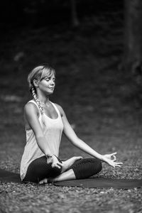 Young woman meditating in lotus position at park