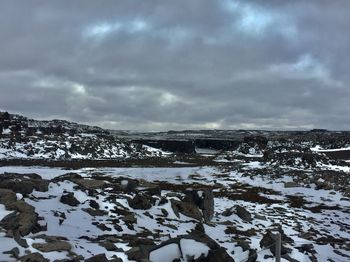 Scenic view of snow covered land against sky