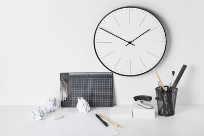 Close-up of clock on table against white background