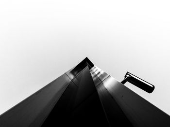 Low angle view of building and security camera against clear sky