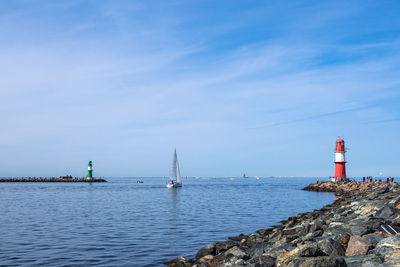 Lighthouse by sea against sky