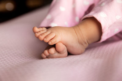 Low section of baby on bed