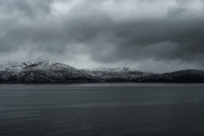 Scenic view of lake against sky during winter