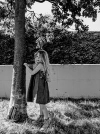 Cute girl standing by tree in park