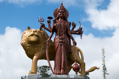 Low angle view of statue against temple against sky