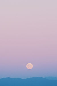 Scenic view of moon in mountains against clear sky