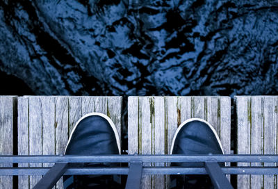 Low section of person standing on bridge