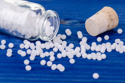 Close-up of pills spilling from bottle