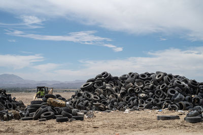 Stack of hay bales on field against sky