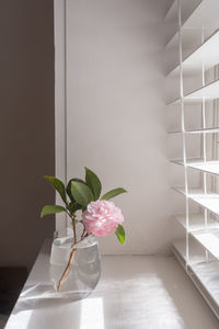 Flower vase on table against wall at home