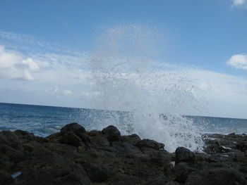 Waves splashing on sea against sky