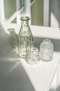 Three glass vases on the table in the interior of the house.