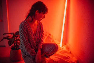 Woman holding red lights at home