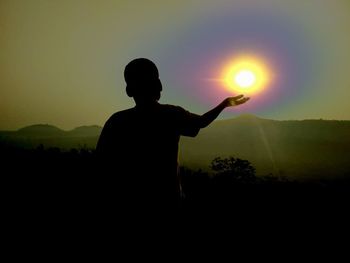 Silhouette man standing against sky during sunset