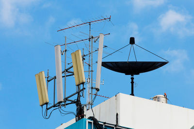 Low angle view of communications tower against blue sky