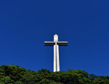 Low angle view of cross against blue sky