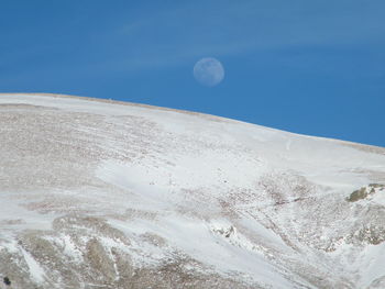 Scenic view of snowcapped mountains against blue sky