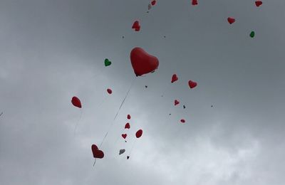 Low angle view of balloons flying against sky