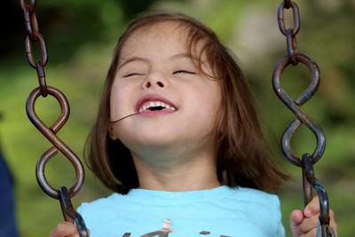 Close-up of smiling girl on swing