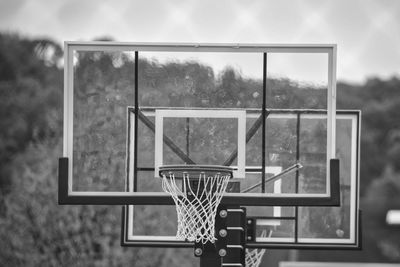 Basketball hoop against sky seen through glass window