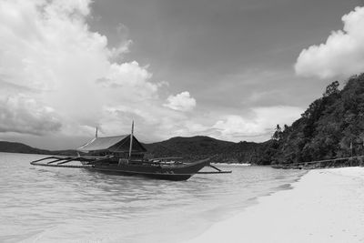 Ship moored on sea against sky