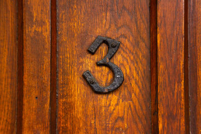 House number 3 on a wooden front door 