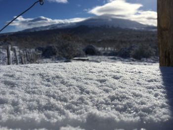 Close-up of snow on mountain against sky