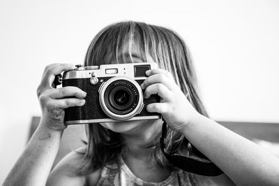 Close-up of girl photographing while sitting at home