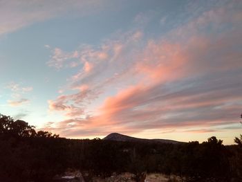 Scenic view of silhouette mountains against sky at sunset