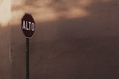 Road sign against wall