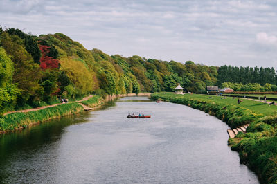 Scenic view of river by trees against sky