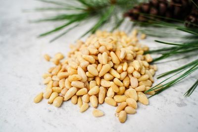 Pine nuts in a rustic metal cup vertical view