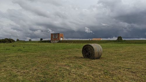 Hay bales on field against sky