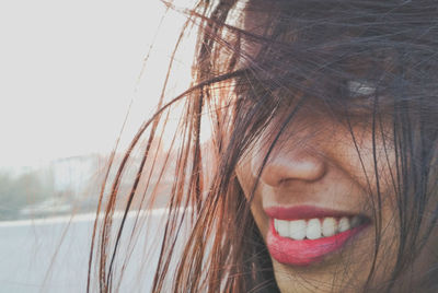 Close-up of thoughtful woman with tousled hair outdoors