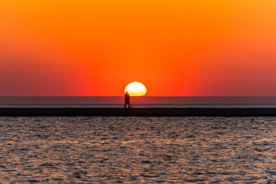 Scenic view of sea against orange sky