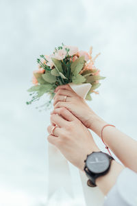 Cropped hands of couple holding bouquet