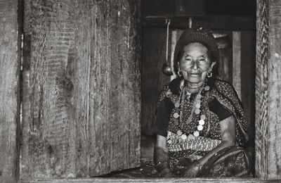 Portrait of smiling woman sitting on doorway