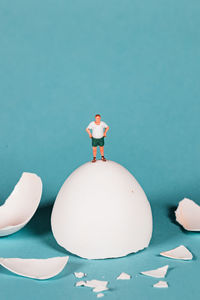 Close-up of figurine over blue background