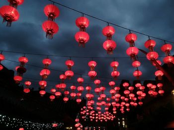 Low angle view of illuminated lanterns hanging against sky