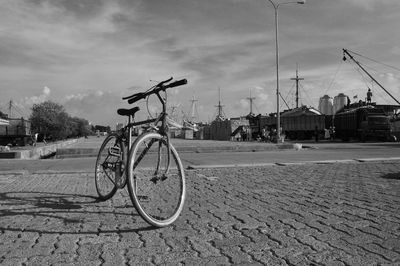 Bicycle on street in city against sky