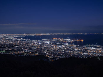 Aerial view of illuminated cityscape against sky at night