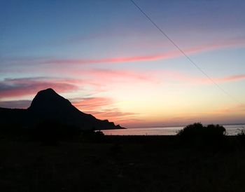 Scenic view of silhouette mountain against sky at sunset