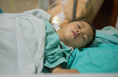 Close-up of boy sleeping on bed in hospital