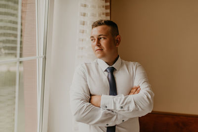 Portrait of doctor standing against wall