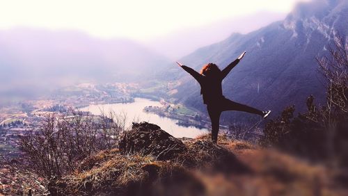 Silhouette woman standing on mountain against sky during winter